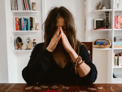 Stock photo of woman crying over a table.