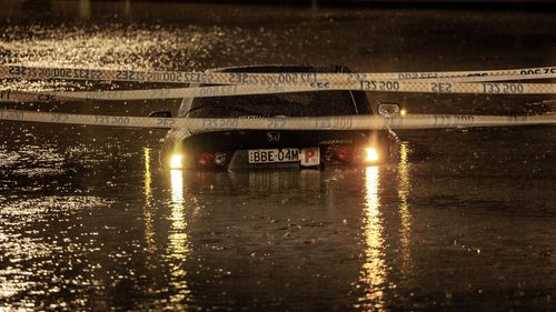 A p-plater's car is submerged in flood waters in Sydney