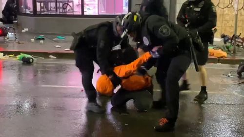 A suspected looter is tackled by police and wrestled to the ground. A reporter later filmed one of the police officer's using his knee on the man's neck.