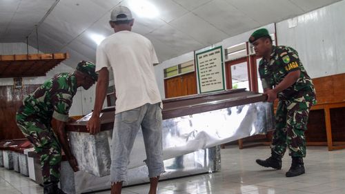 Indonesian soldiers prepare coffins