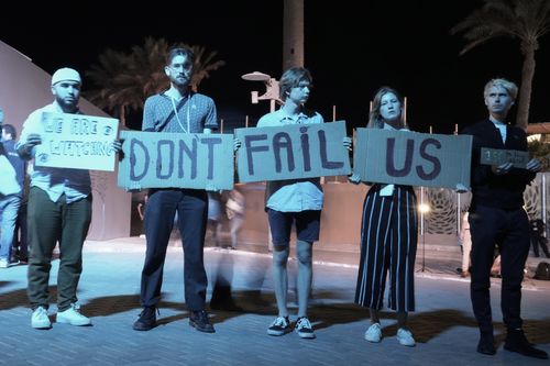 Activists hold signs at the COP27 U.N. Climate Summit, Saturday, Nov. 19, 2022, in Sharm el-Sheikh, Egypt. (AP Photo/Nariman El-Mofty)