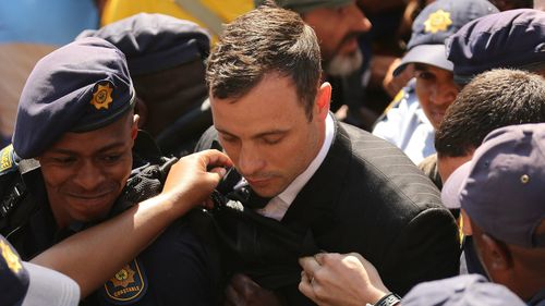 Oscar Pistorius is escorted by police. (AAP)