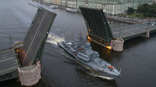 A warship sails past the Dvortsovy (Palace) drawbridge rising above the Neva River. (AAP)