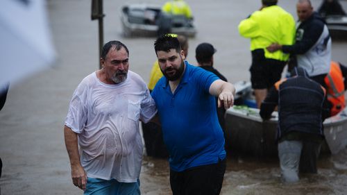 A man is guided to safety in Lismore NSW.