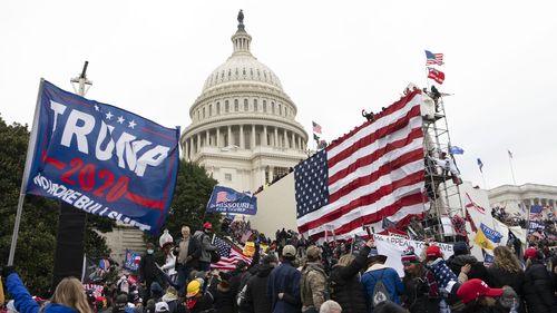 FILE - Violent insurrectionists loyal to President Donald Trump stand outside the US Capitol in Washington on January 6, 2021. 