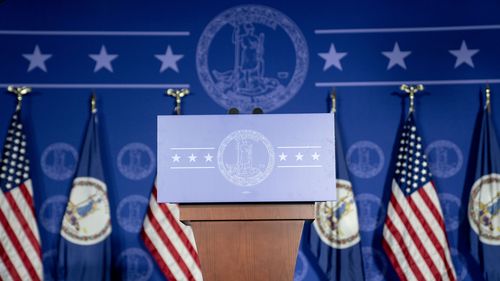 American and Virginia state flags near a podium during an election night event for Terry McAuliffe. 