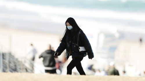 A woman wears a face mask at Bondi Beach in Sydney.