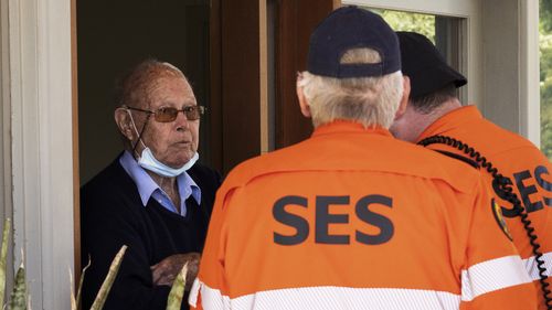 State Emergency Service (SES) workers go door to door as evacuation orders are made in advance of expected major flooding.