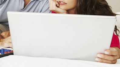 Man and woman doing budget on computer