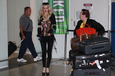 It looks like a permanent move - check out that luggage!<br/><br/>The model got her PDA on with Geoffrey Edelsten in the arrivals lounge, all caught on camera. It's good to see Gabi likes to travel in comfort (hmm)... wearing a corset, leather gloves and eightinch heels. Obvs.