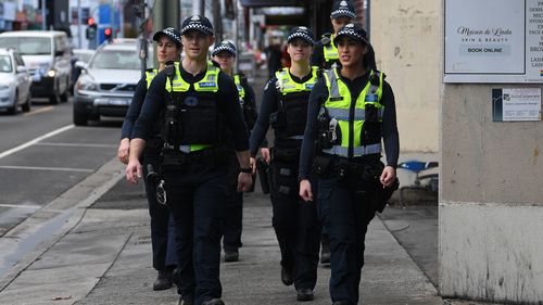 Victoria Police officers patrol near Victoria Street in Richmond.