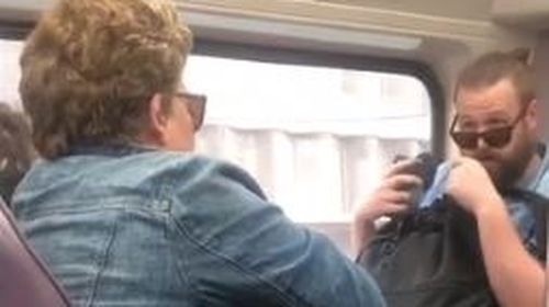 Woman coughs on commuter sparking bitter argument amid coronavirus fears.