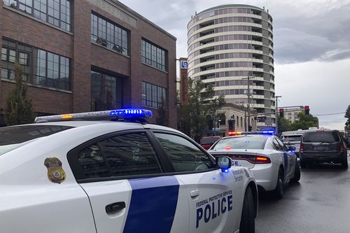 Police respond to a shooting at an apartment building, top rear, in Vancouver, Wash., Thursday, Oct. 3, 2019. Authorities said multiple people were struck. (AP Photo/Gillian Flaccus)