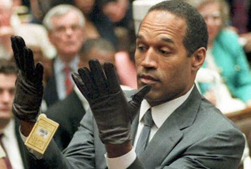 OJ Simpson tries on the infamous gloves in court during his 1995 trial. (AAP)