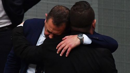 MPs Gavin Pearce (left) and  Phillip Thompson embrace in the House of Representatives.