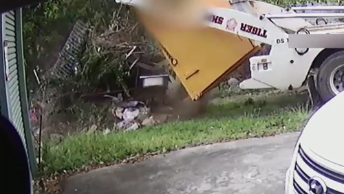 A skip bin supplier has been caught on CCTV dumping a load of rubbish in a customer's front yard.