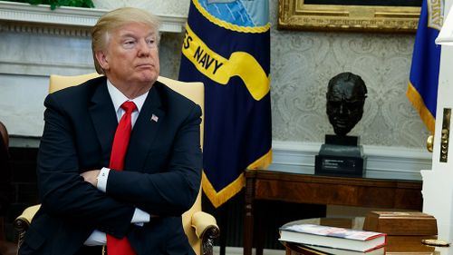 President Donald Trump listens during a meeting with North Korean defectors where he talked with reporters about allowing the release of a secret memo. (AAP)