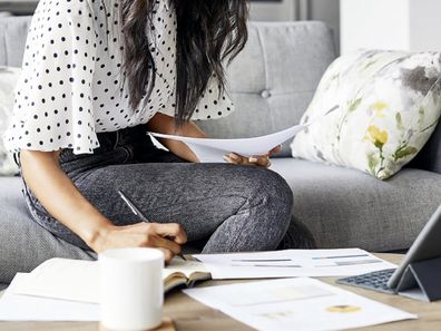 Woman using tablet paper pen to do her budget