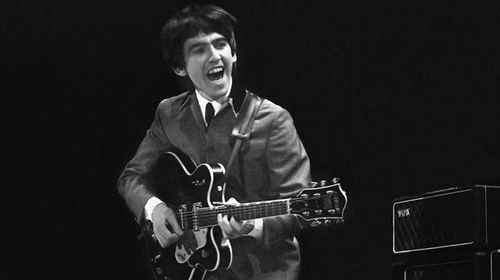 George Harrison performing with the Beatles in 1964. (AAP)