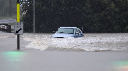 A vehicle is submerged in flood water in the suburb of Oxley in Brisbane. 