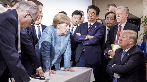 German Chancellor Angela Merkel, center, speaks with U.S. President Donald Trump, seated at right, during the G7 Leaders Summit in La Malbaie, Quebec, Canada (Photo: June 2018)