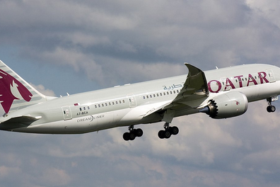 A Qatar Airways plane flying through the sky