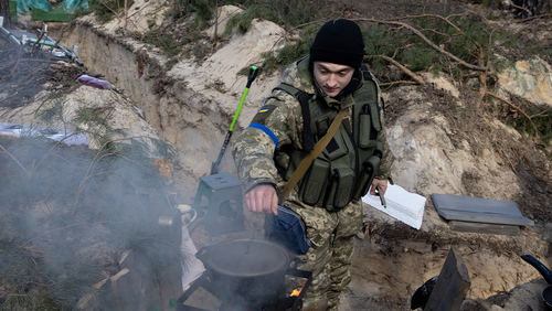 A member of a Territorial Defense unit makes tea while guarding a defensive position on the outskirts of Kyiv on March 17, 2022 in Kyiv, Ukraine.