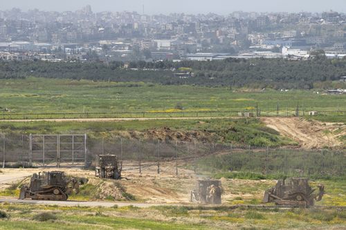 Israeli army bulldozers are seen near the Gaza Strip border, in southern Israel, Thursday, March 21, 2024.