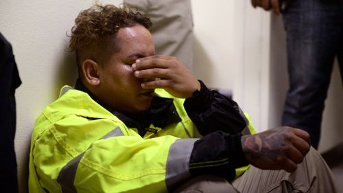 Rescue team member Jonathan Cruz cries on the floor. (AP)