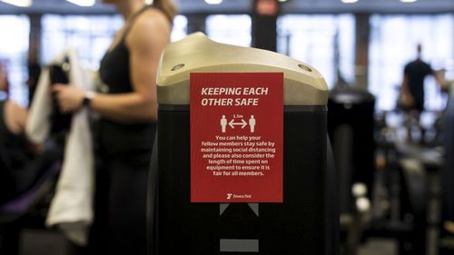 A sign advising customers too social distance while working out at a Fitness First Gym.