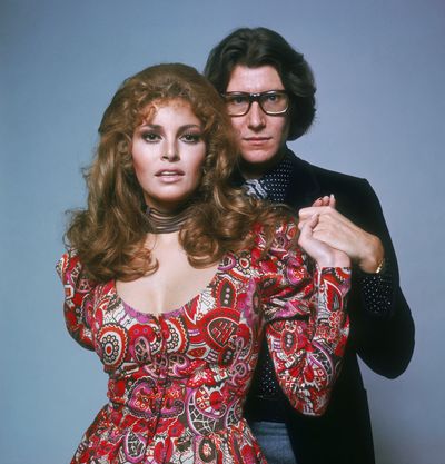 Yves Saint Laurent (here with Raquel Welch in 1975) has become the subject of duelling biopics in recent years.