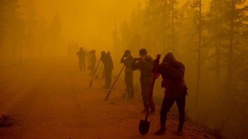 Volunteers pause while working at the scene of forest fire near Kyuyorelyakh village at Gorny Ulus area west of Yakutsk.