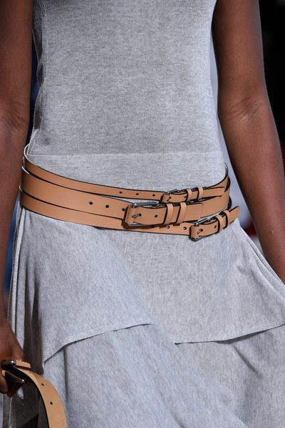 Belts in neutral leather, layered for a modern twist.