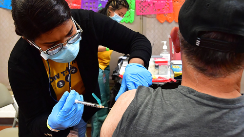 Registered Nurse Mariam Salaam administers the Pfizer booster shot at a Covid vaccination and testing site decorated for Cinco de Mayo at Ted Watkins Park in Los Angeles on May 5.