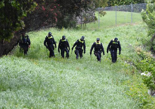 Police conduct a line search at Dandenong Creek in Bayswater in Melbourne. The police were looking for clues after Paul Virgona was found dead in a van on the Eastlink Freeway.