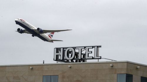A plane passes over the Sofitel Hotel near London's Heathrow. Tuesday, Jan. 26, 2021.
