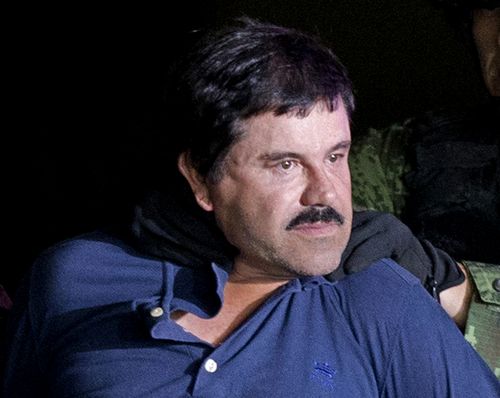 In this Jan. 8, 2016 file photo, a handcuffed Joaquin "El Chapo" Guzman is made to face the press as he is escorted to a helicopter by Mexican soldiers and marines at a federal hangar in Mexico City. Guzman is scheduled to appear in person in a federal court in New York. A judge initially ruled that Guzman would appear in court by video on Friday, Feb. 3, rather than have marshals escort him to and from a high-security Manhattan jail cell. The order was changed after his lawyers asked the judge to reconsider. (AP Photo/Eduardo Verdugo, File)