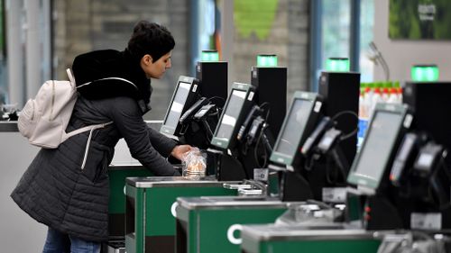 A woman uses a self-service checkout at a Woolworths store in Sydney. (AAP)