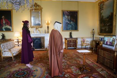 Queen Elizabeth II, in residence at Windsor Castle, appears on a screen via videolink, during a virtual audience to receive Fahad bin Mohammed Al-Attiyah, Ambassador of Qatar, and Sheikha Raya Khalifa Abdulla Khalifa Al Khalifa (L), at Buckingham Palace on March 22, 2022 in London, England 