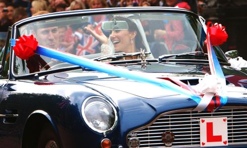 The car was festooned with L-plates, ribbons and tin cans attached to the bumper.