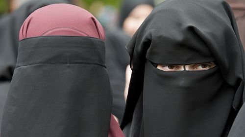 two women are seen each wearing a niqab.