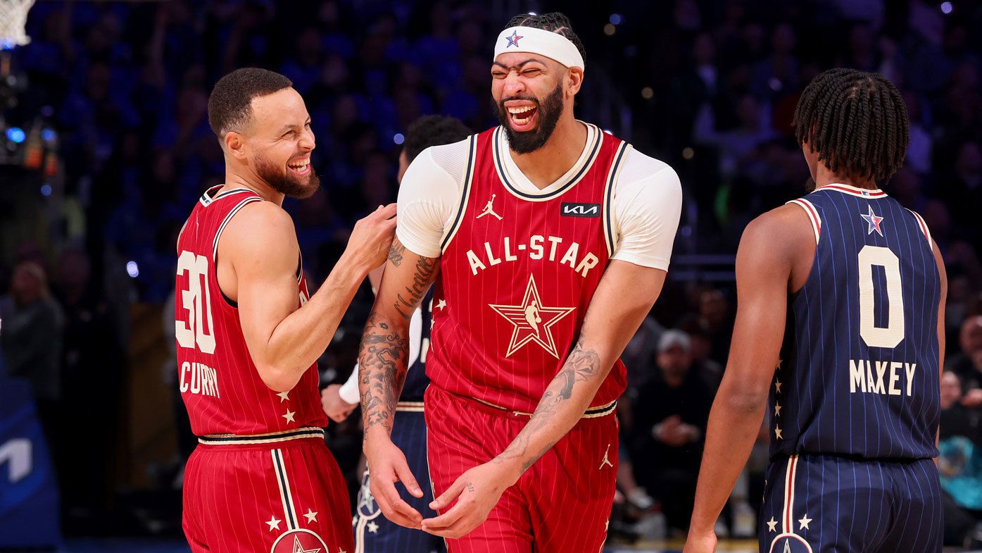 Steph Curry shares a joke with teammate Anthony Davis in the 2024 NBA All-Star game.
