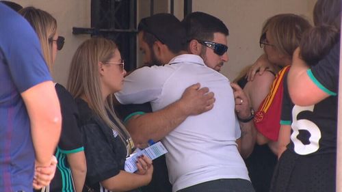 Mourners hugged as the hearse pulled up.