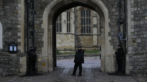 Police guard the Henry VIII gate at Windsor Castle at Windsor, England on Christmas Day, Saturday, Dec. 25, 2021. Britain's Queen Elizabeth II has stayed at Windsor Castle instead of spending Christmas at her Sandringham estate due to the ongoing COVID-19 pandemic. (AP Photo/Alastair Grant)