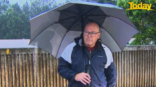 Steve Krieg, Mayor of Lismore, stands in front of a rising Wilsons River. At the time of his live cross the river was 91cm from breaching the levee. 