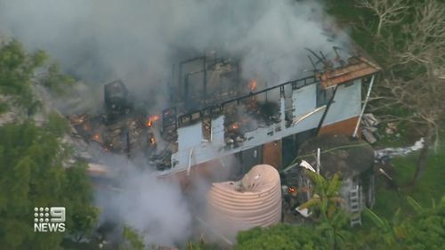 A Queensland family of eight has escaped a burning house after receiving the help of a complete stranger.