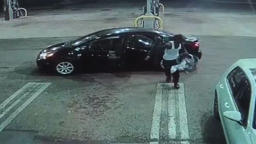 The thief took the baby to the entrance of the petrol station kiosk. The thief was seen struggling to get the baby in the car seat out of the car he'd stolen. Picture:  WPTV