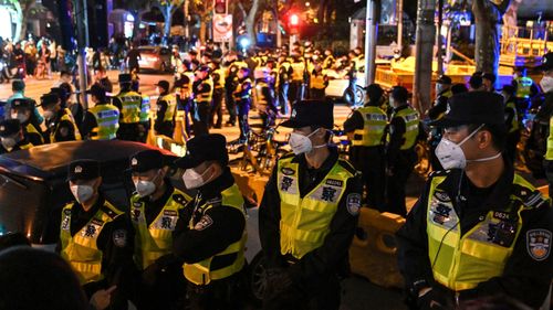 Police officers block Shanghai's Urumqi Road, as a wave of protests occur across China.