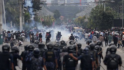Riot police personnel chase demonstrators in the Nepalese capital during Monday's protest.