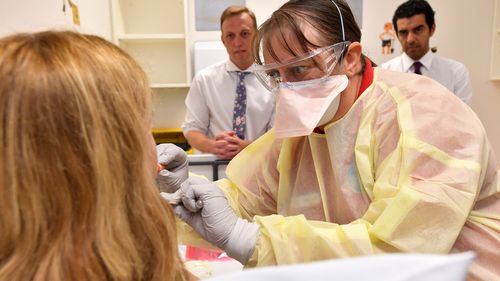 A GP performs a mock coronavirus examination on a patient inside the fever clinic at the Prince Charles Hospital in Brisbane.